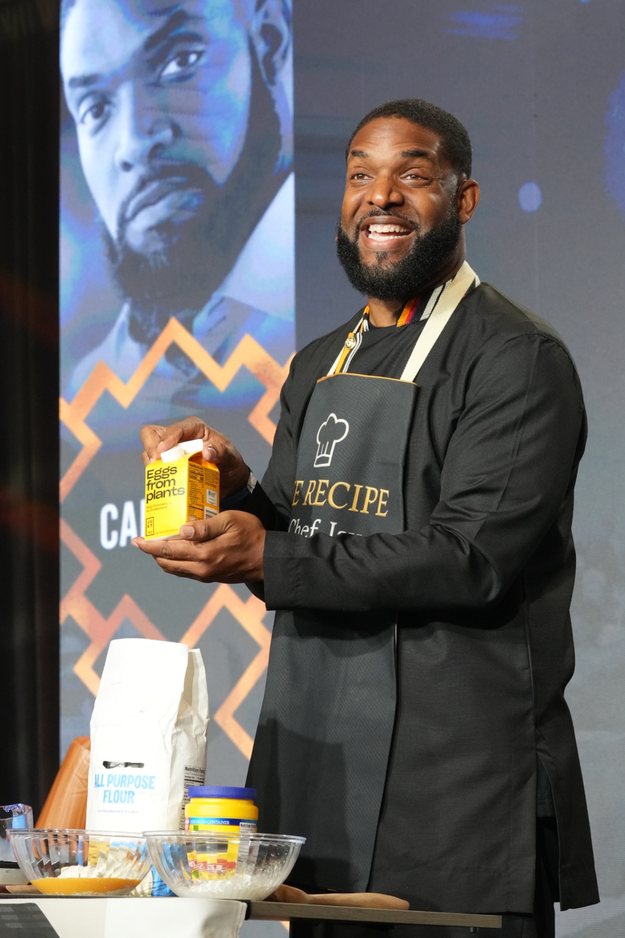 Jay Cameron smiling on stage during a live demonstration