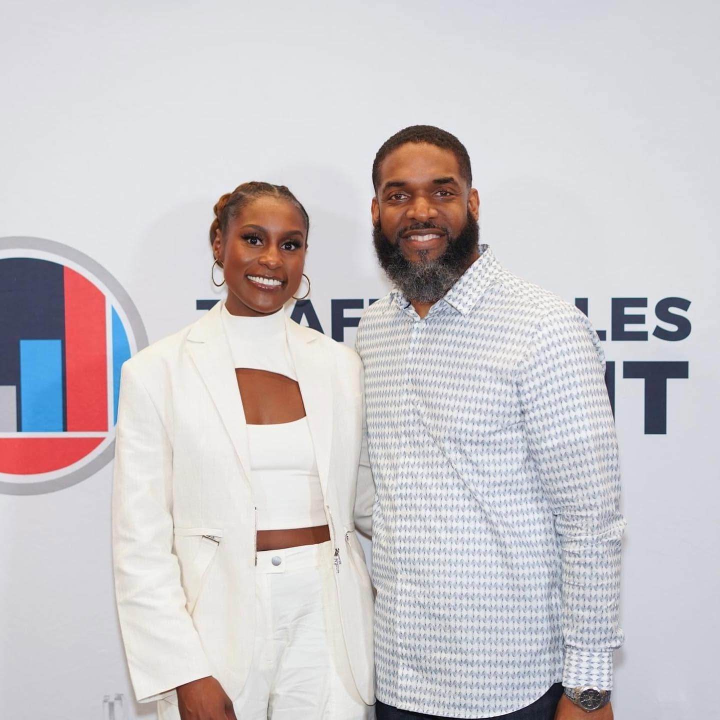 Jay Cameron at an event backdrop with another guest