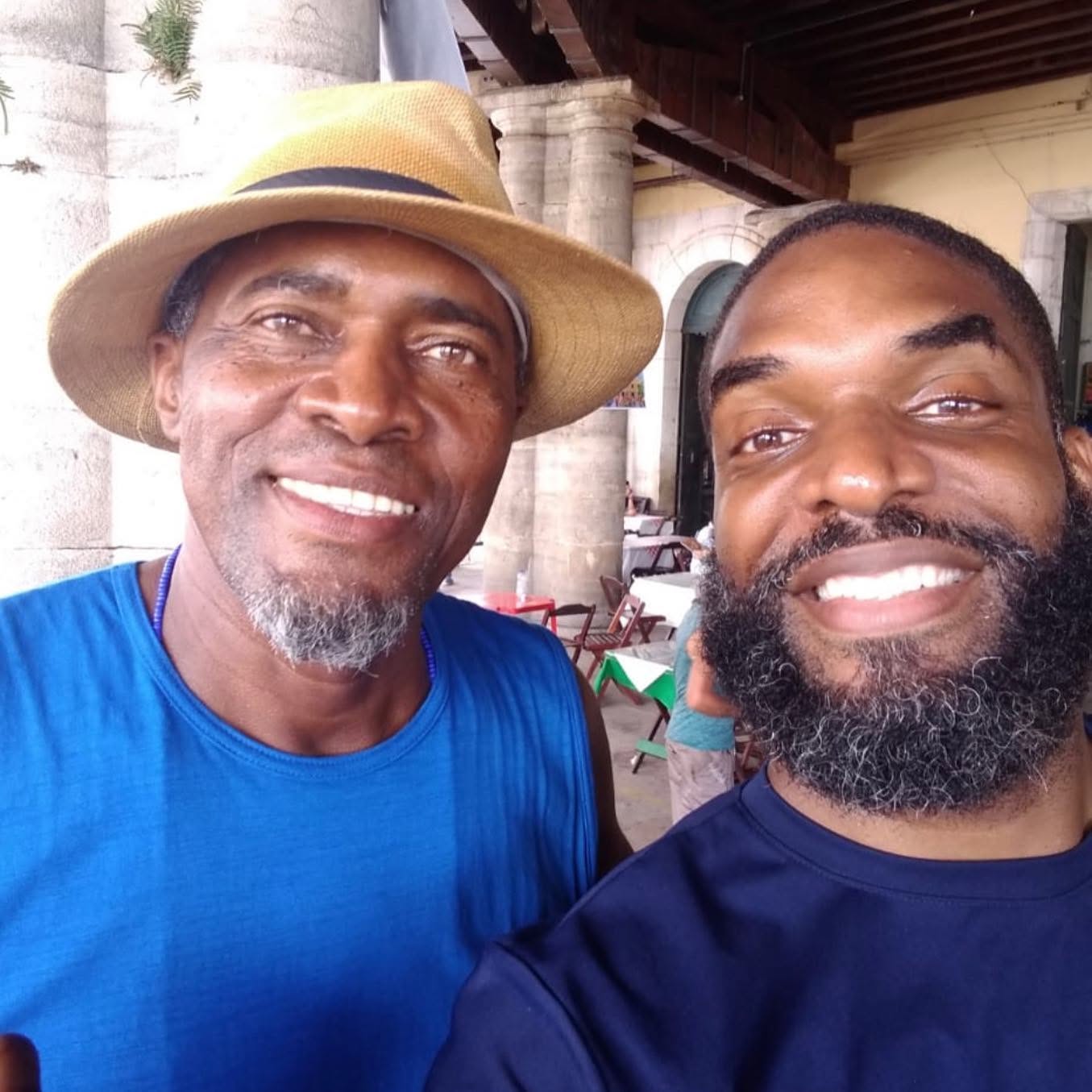 Jay Cameron smiling alongside a relative under a colonnade