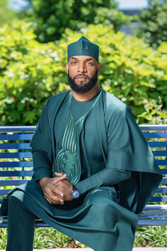 Jay Cameron seated on a bench in green traditional dress