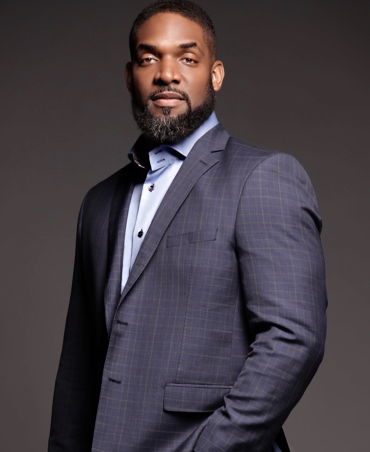 Studio portrait of Jay Cameron in a grey checked suit