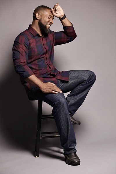 Jay Cameron seated on a stool, laughing